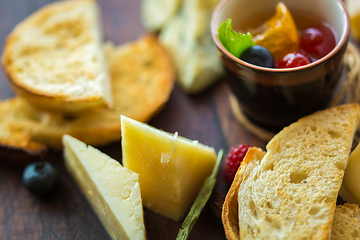 Image showing Assorted cheese on a wooden board.