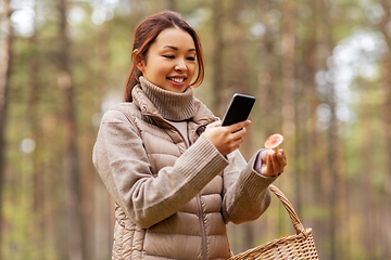 Image showing asian woman using smartphone to identify mushroom