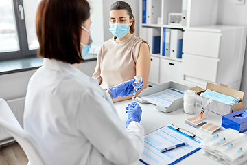 Image showing female doctor with syringe vaccinating patient