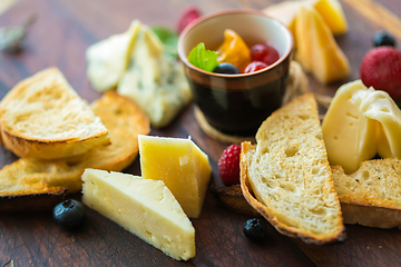 Image showing Assorted cheese on a wooden board.