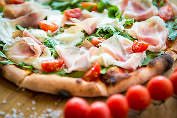 Image showing Pizza with cherry tomatoes, prosciutto and ruccola