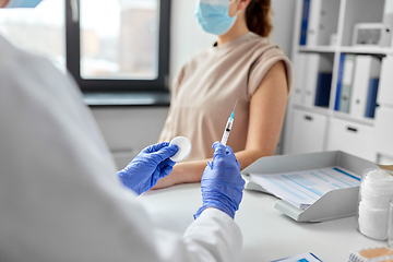 Image showing female doctor with syringe vaccinating patient