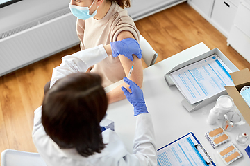 Image showing female doctor with syringe vaccinating patient