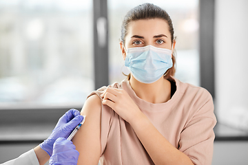 Image showing female doctor with syringe vaccinating patient