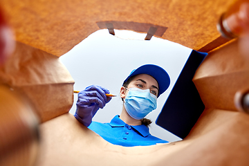 Image showing delivery girl in gloves and mask with food in bag