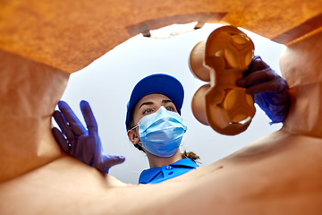 Image showing delivery girl in gloves and mask with food in bag