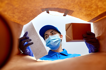 Image showing delivery girl in gloves and mask with food in bag