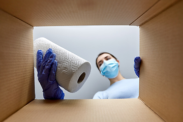 Image showing woman in mask taking cleaning supplies from box