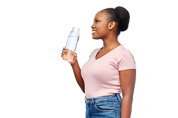 Image showing happy african woman drinks water from glass bottle