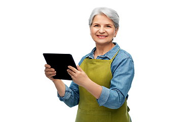 Image showing happy senior woman in garden apron with tablet pc