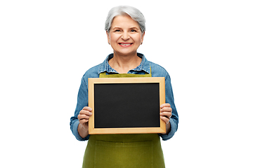 Image showing happy senior woman in garden apron with chalkboard