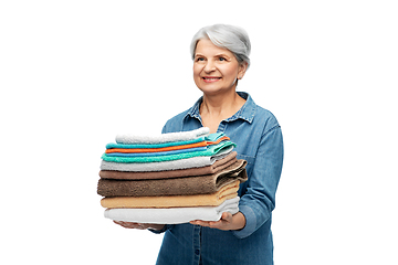 Image showing smiling senior woman with clean bath towels