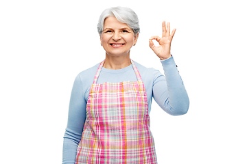 Image showing smiling senior woman in apron showing ok gesture