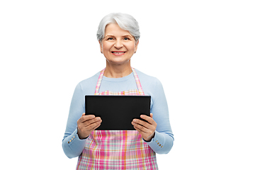 Image showing smiling senior woman in apron with tablet computer