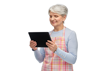 Image showing smiling senior woman in apron with tablet computer