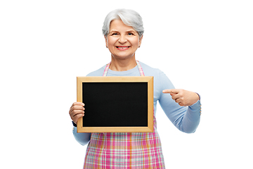 Image showing smiling senior woman in apron with chalkboard