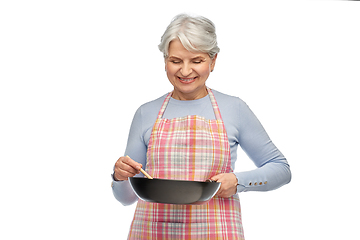 Image showing smiling senior woman in apron with frying pan