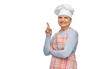 Image showing smiling senior woman or chef pointing finger up