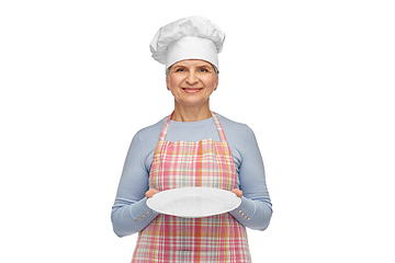 Image showing smiling senior woman or chef holding empty plate