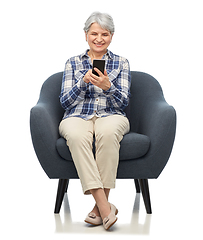 Image showing smiling senior woman with smartphone in chair