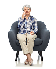 Image showing senior woman calling on smartphone in armchair