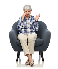 Image showing senior woman calling on smartphone in armchair