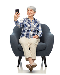 Image showing smiling senior woman sitting in modern armchair