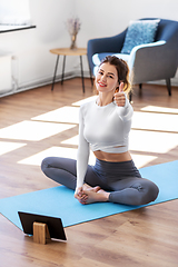 Image showing young woman with tablet pc doing yoga at home