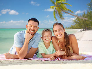 Image showing happy family lying over tropical beach background