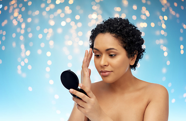 Image showing african american woman looking to mirror