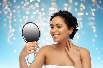 Image showing smiling african american woman looking to mirror