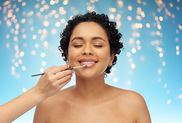 Image showing happy woman and hand of make up artist with brush