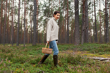 Image showing woman with basket picking mushrooms in forest