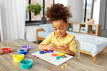 Image showing little girl with modeling clay playing at home