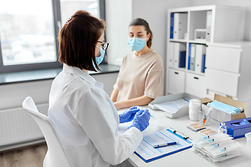 Image showing female doctor with syringe and patient at hospital