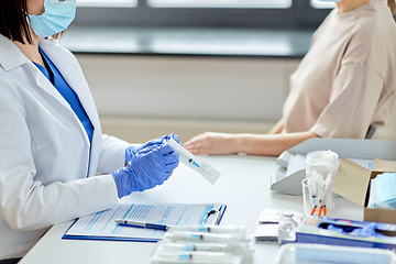 Image showing female doctor with syringe and patient at hospital