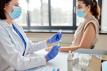 Image showing female doctor with syringe vaccinating patient