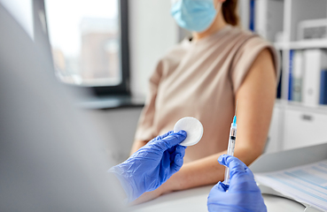 Image showing female doctor with syringe vaccinating patient