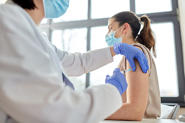 Image showing female doctor with syringe vaccinating patient