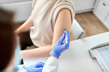 Image showing female doctor with syringe vaccinating patient