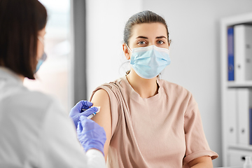 Image showing female doctor with syringe vaccinating patient