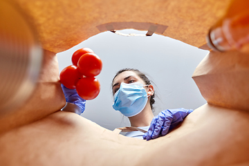 Image showing woman in gloves and mask with food in paper bag