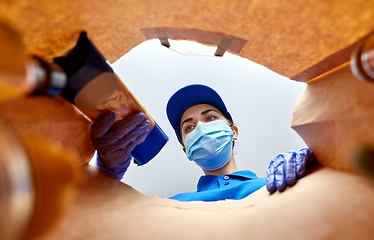 Image showing delivery girl in gloves and mask with food in bag