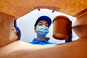 Image showing delivery girl in gloves and mask with food in bag