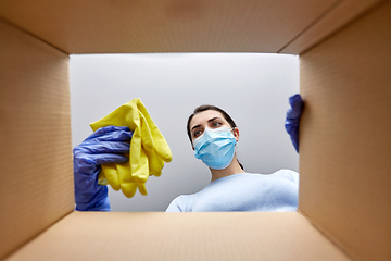 Image showing woman in mask taking cleaning supplies from box