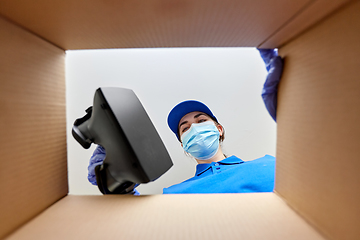 Image showing woman in mask packing vr glasses to parcel box