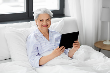 Image showing senior woman with tablet pc in bed at home bedroom