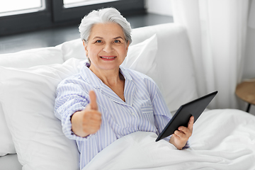 Image showing senior woman with tablet pc in bed at home bedroom