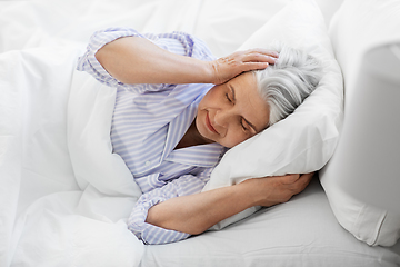 Image showing annoyed senior woman with headache in bed at home