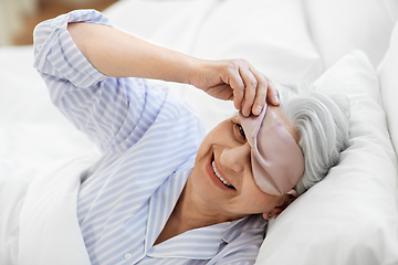 Image showing senior woman with eye sleeping mask in bed at home